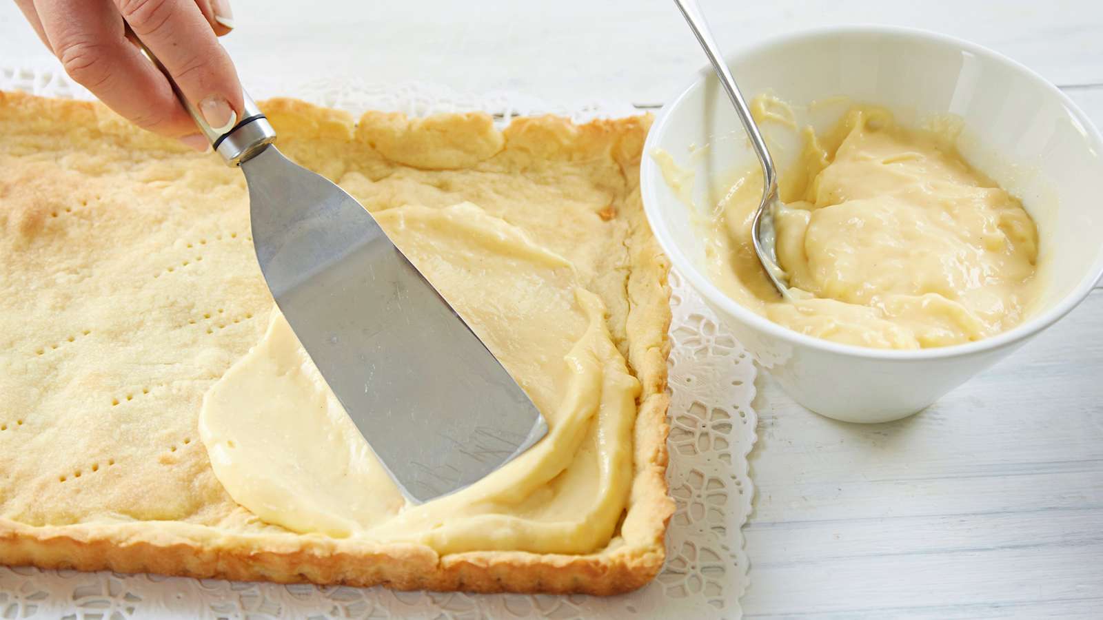 Irrota torttupohja vuoasta heti paistamisen jälkeen. Anna jäähtyä ritilän päällä. Siirrä pohja kakkupaperin päälle tai tarjoiluvadille ja täytä kylmällä vaniljakiisselillä.
