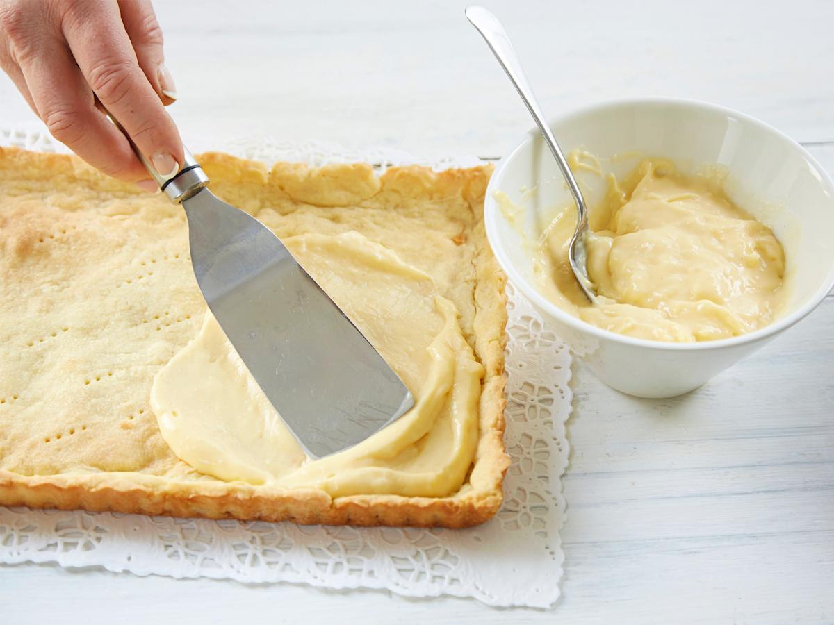 Irrota torttupohja vuoasta heti paistamisen jälkeen. Anna jäähtyä ritilän päällä. Siirrä pohja kakkupaperin päälle tai tarjoiluvadille ja täytä kylmällä vaniljakiisselillä.