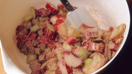 Sekoita perunajauhot, sokeri ja kaneli keskenään. Kääntele seos raparperipalojen joukkoon. Levitä seos pohjan päälle.