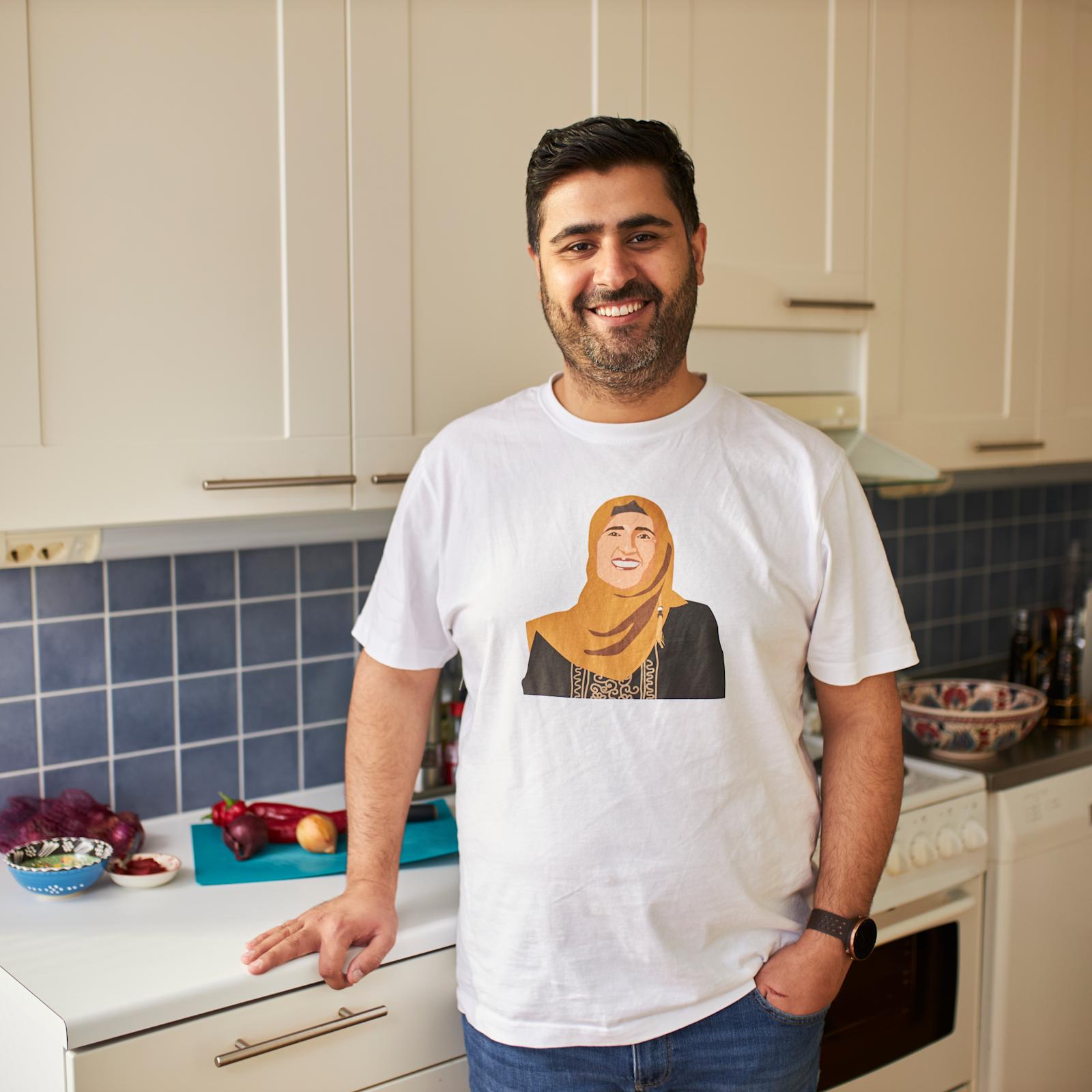 Siva Parlar seisoo keittiössään. Sivalla on t-paita, jossa on hänen äitinsä kuva.