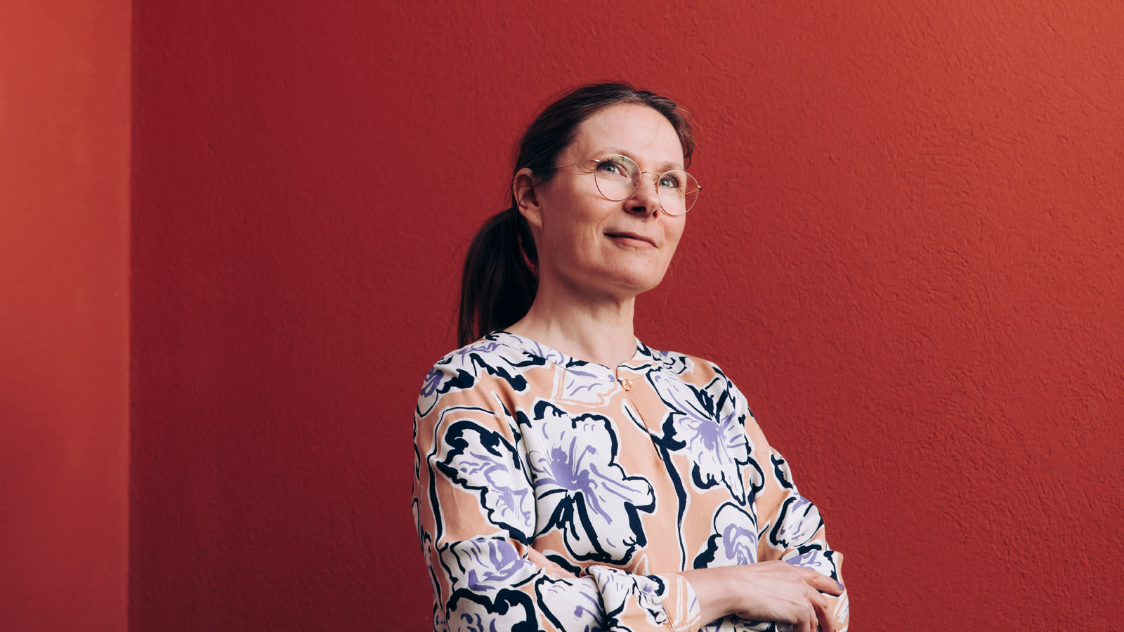 Nanson pääsuunnittelija Noora Niinikoski punaisen seinän edustalla.