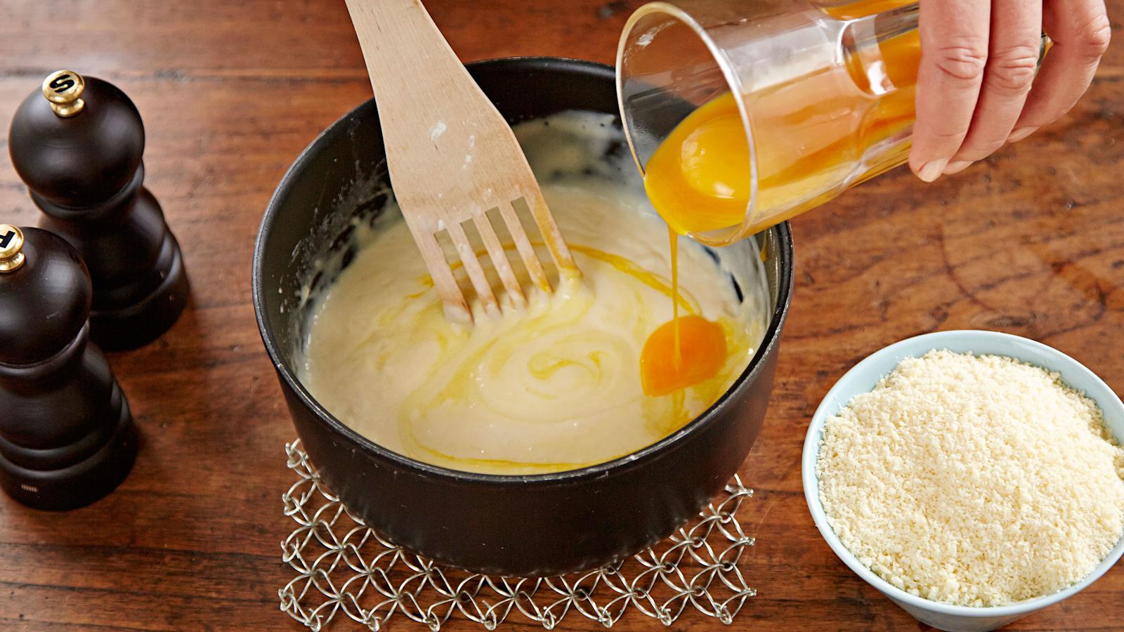 Sekoita kastikkeeseen keltuaiset yksi kerrallaan. Mausta. Lisää juustoraaste.