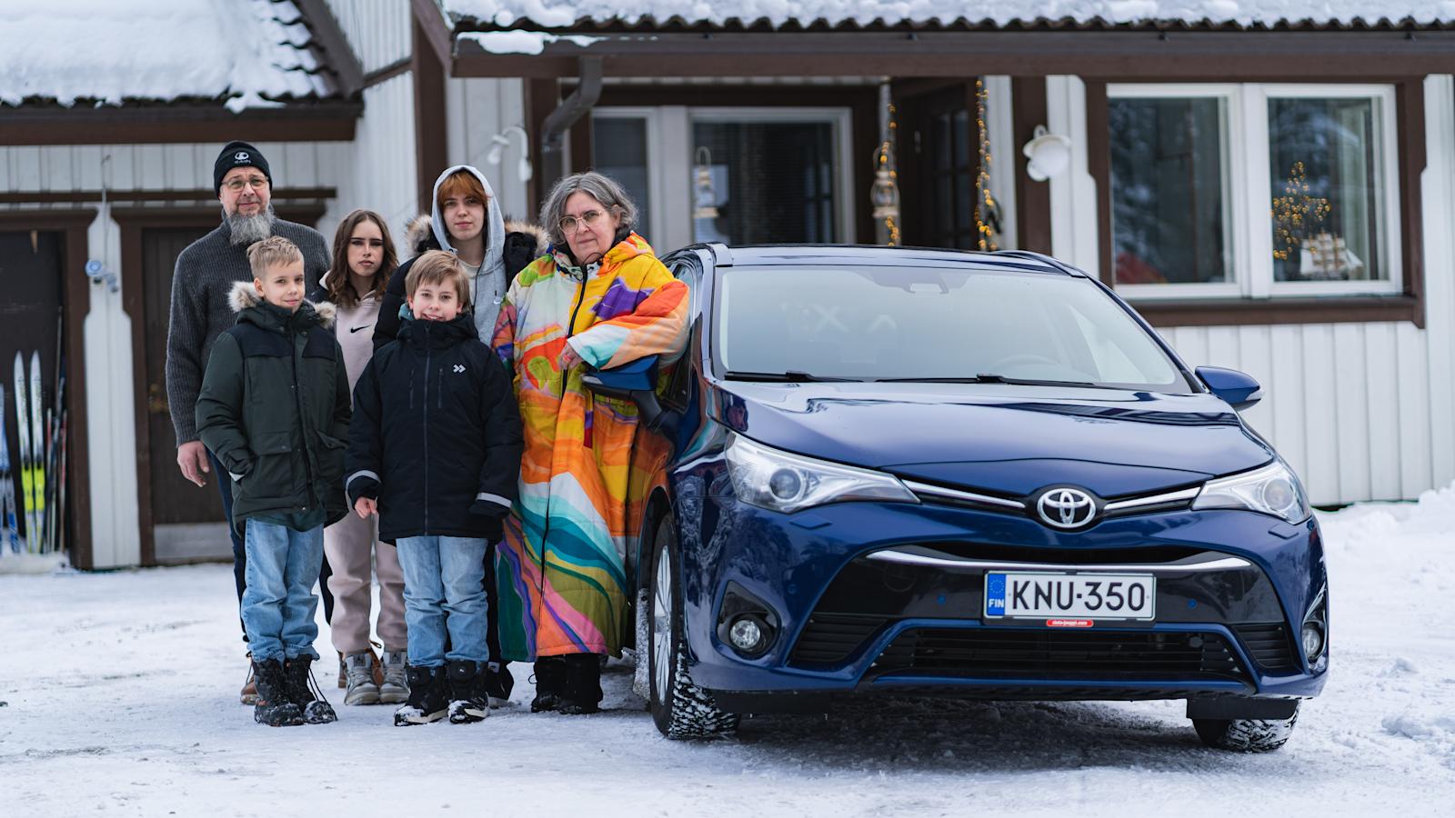 Kuva bonusperheestä. Tuhkasten perhe osti Bonuksilla auton. Kuvassa perhe ja auto.