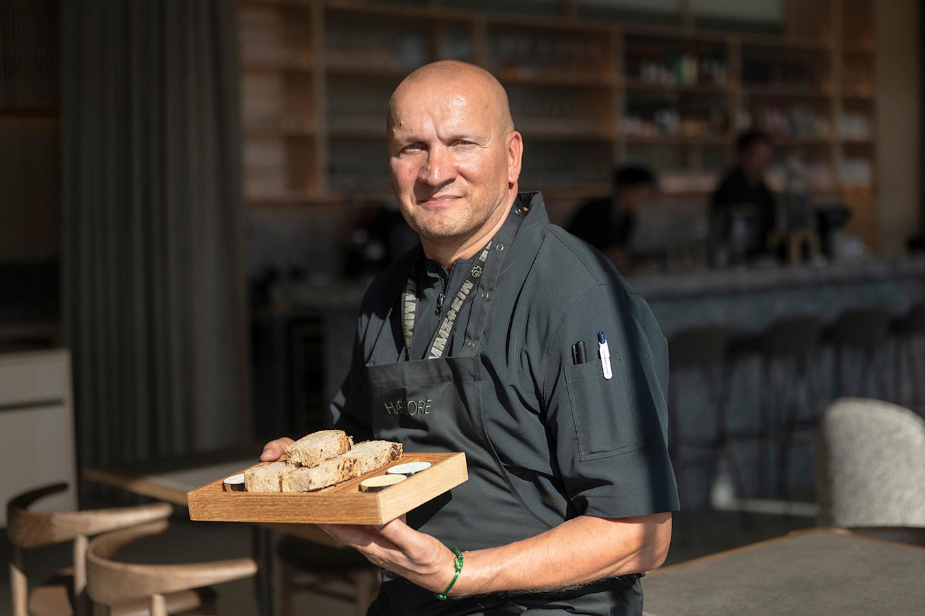 Sauli Kemppainen kuvattuna ravintolassa kädessään tarjottimella leipää