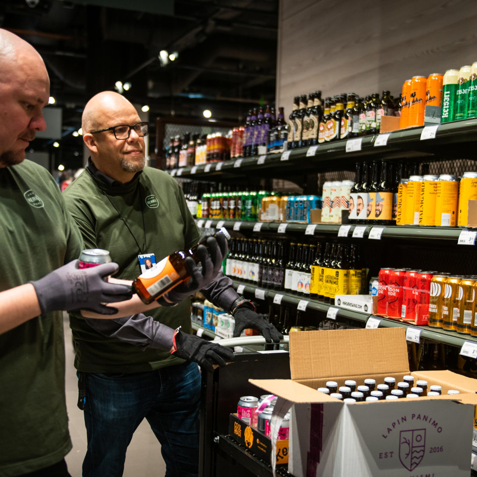 Jarmo Tyynelä (oik.) vastaa tulokkaiden perehdytyksestä. Vltavasta lainaan tullut Aki Rytkönen on kuudetta päivää töissä kaupassa.