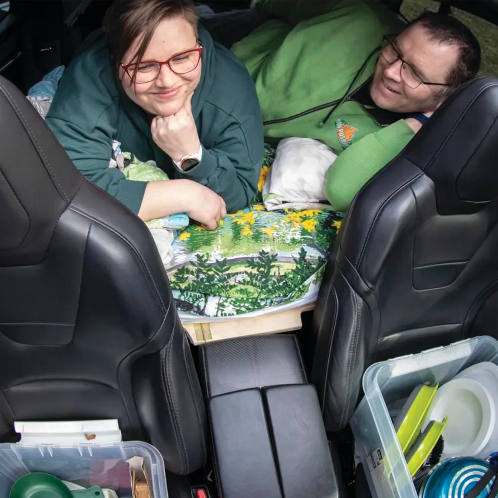 Katja ja Sami Tuomola makoilevat autossaan.