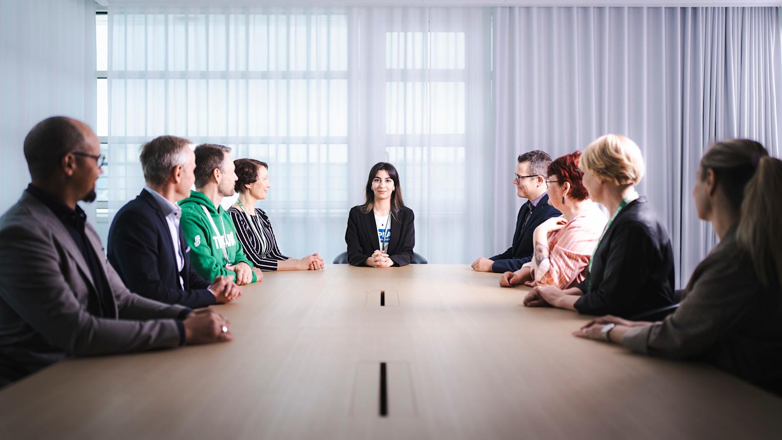 Joudi Chikho istuu pöydän päässä. Pöydän ääressä on SOK:n johtoryhmän jäseniä