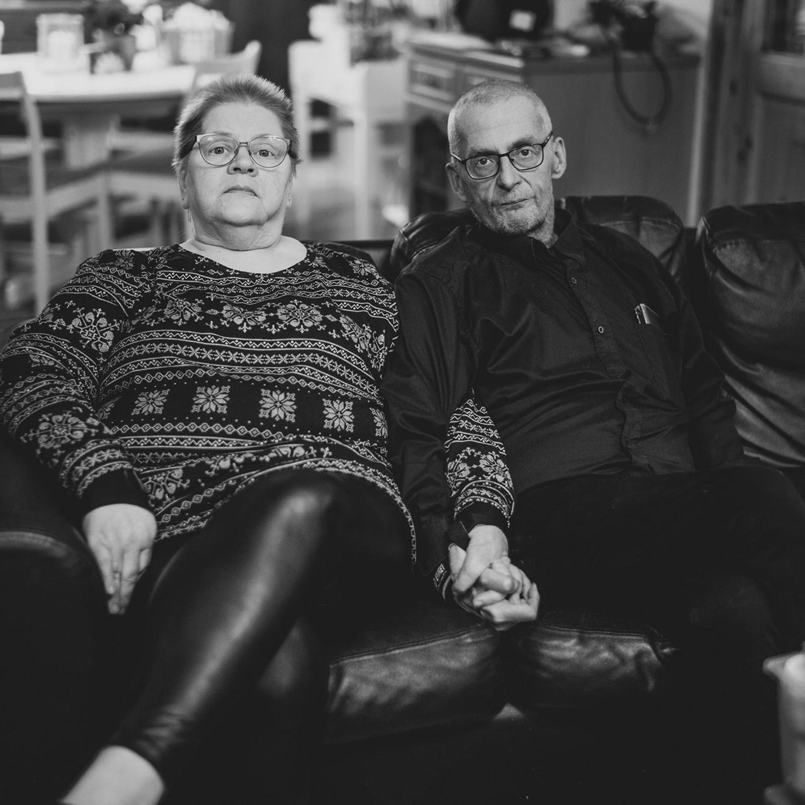 Arja Marjatsalo-Kyllästinen ja Mika Kyllästinen istuvat sohvalla käsi kädessä.