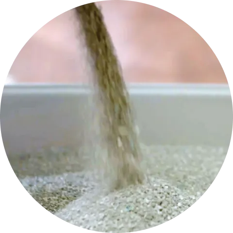 Cat litter pouring into a litter box indicating Low-dust Formulas