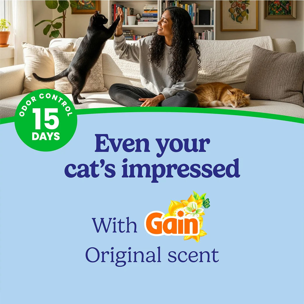 A woman playing with her cat in a a living room. The words "Even your cat's impressed" regarding the Gain Original scent.