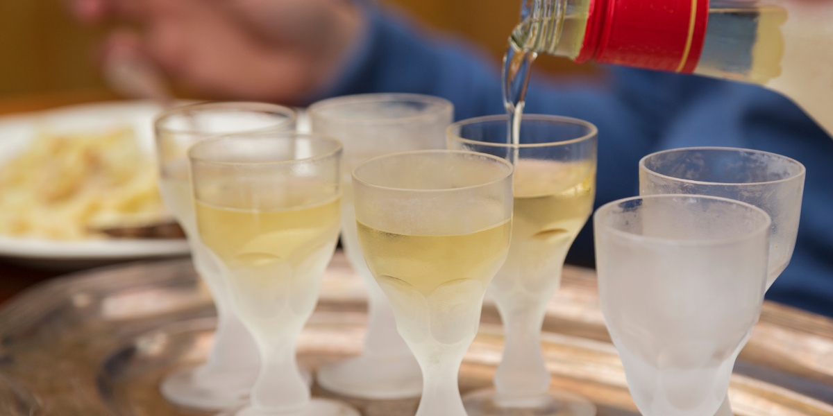 Pouring Aquavit into glasses, a traditional Scandinavian drink liquor