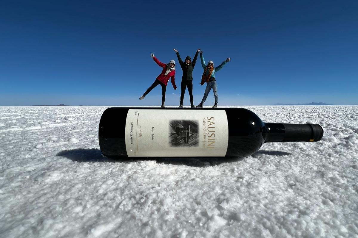 Perspective shot wine bottle during dry season at Salar de Uyuni salt flats Bolivia
