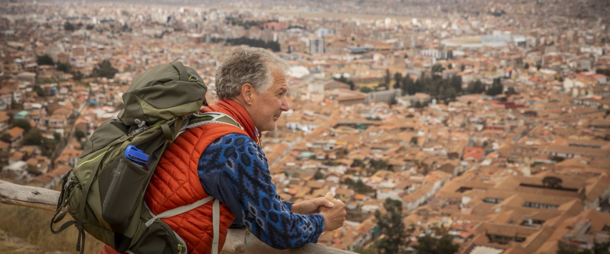 Traveler looking over city aeriel view of Cusco Peru