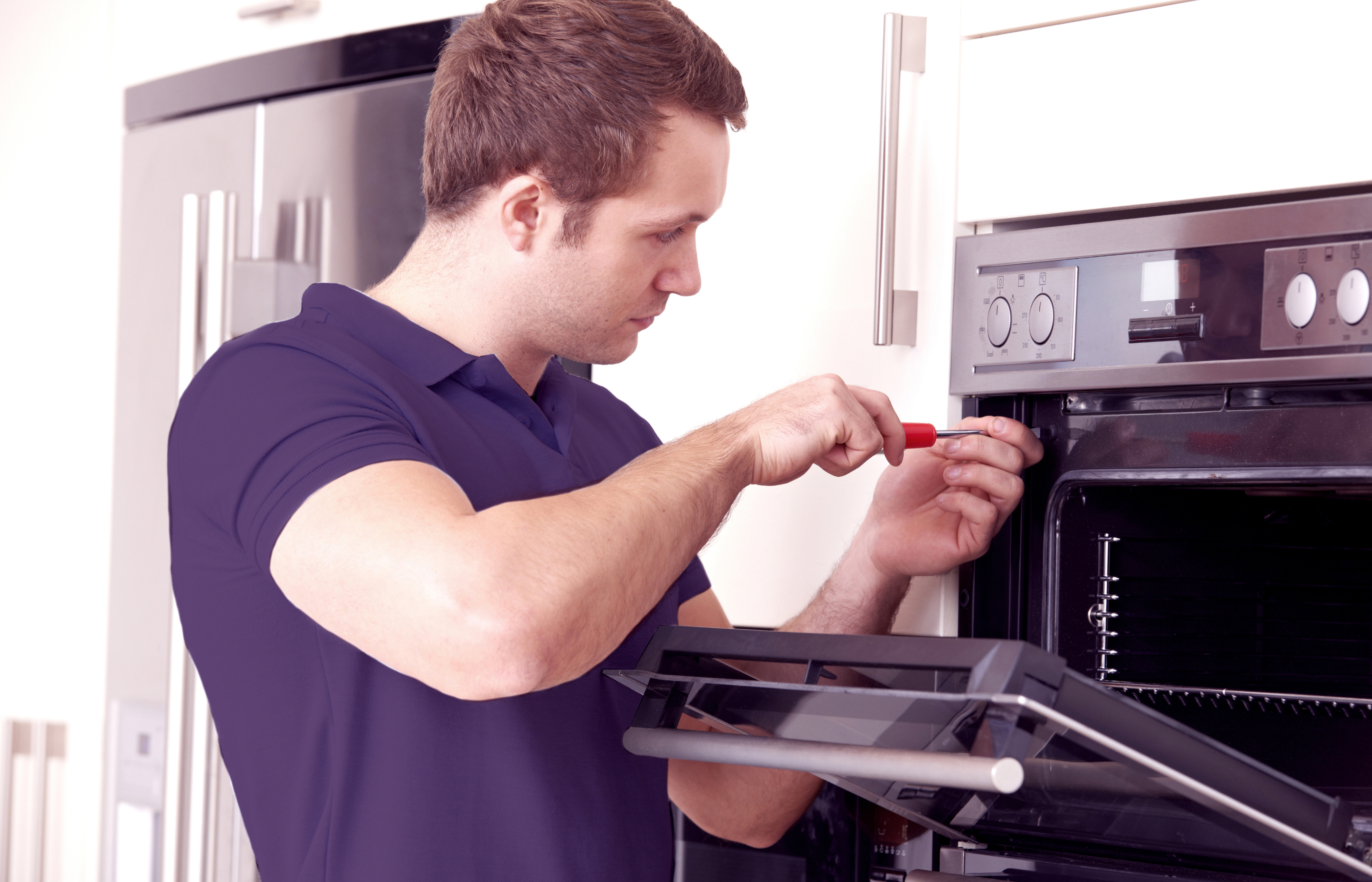 Asurion Appliance+ repair technician fixing oven