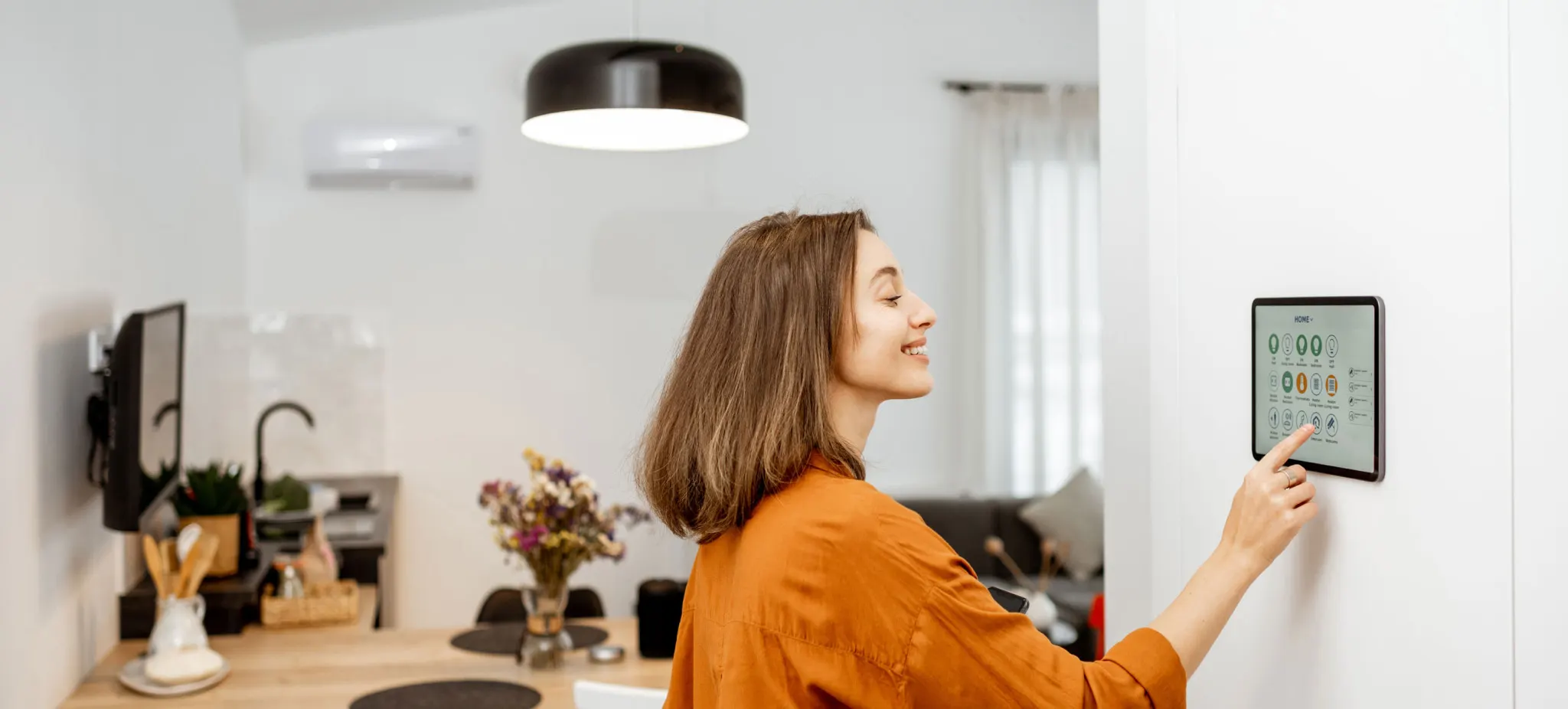 Woman controlling smart home devices using a digital tablet