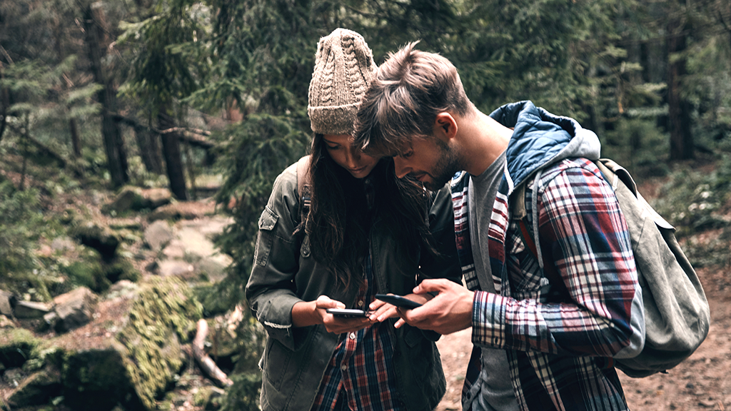 hiking couple with phones