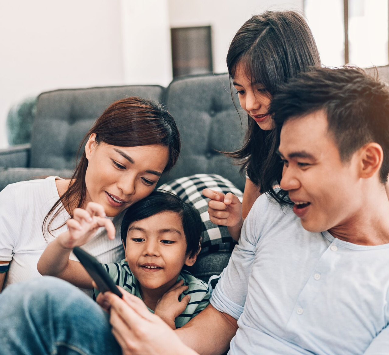 Family gathered around looking at smart phone.