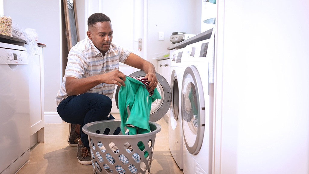 Man pulling laundry out of dryer that's too hot