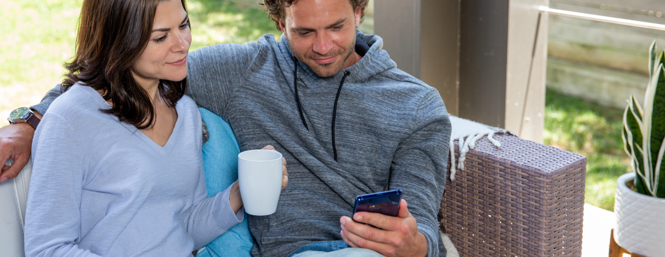 Man and woman looking at phone on porch