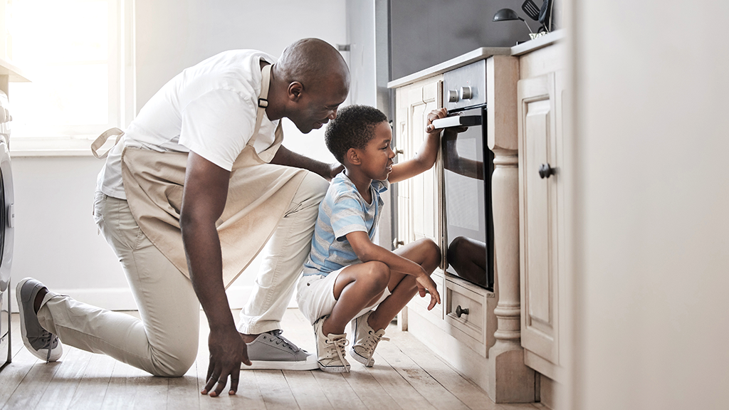 Father and son looking inside oven that's not heating up properly