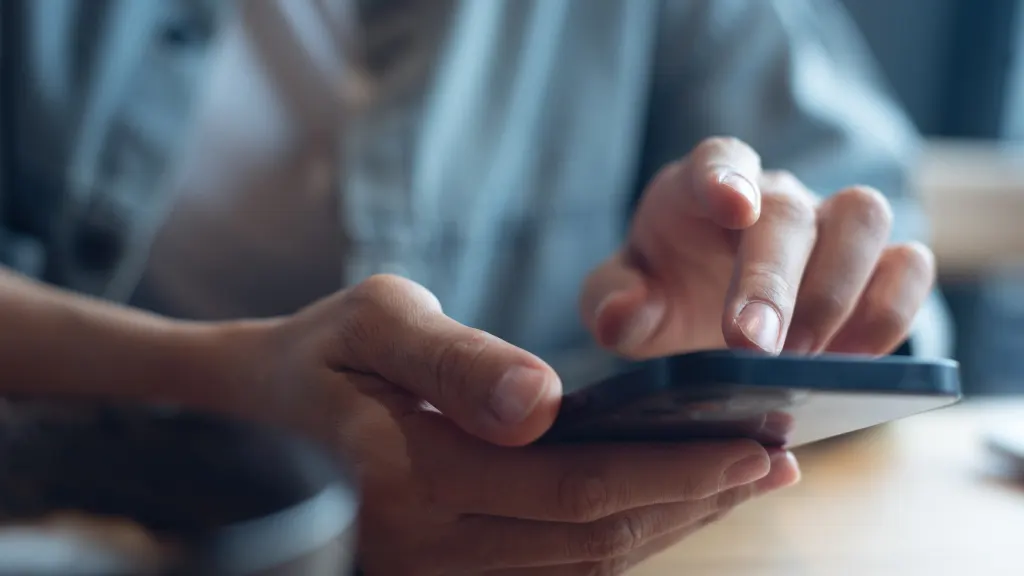 Close up of hands holding and interacting with a smartphone