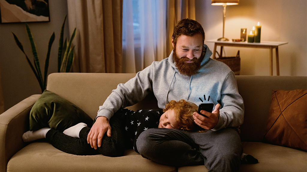 Father looking at smart monitoring on his phone as child sleeps