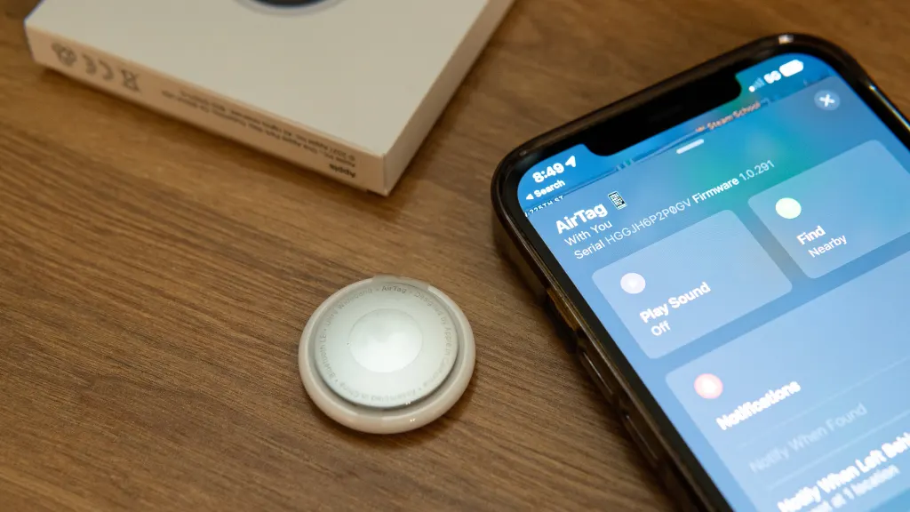 Lifestyle image of an AirTag on a table next to an iPhone