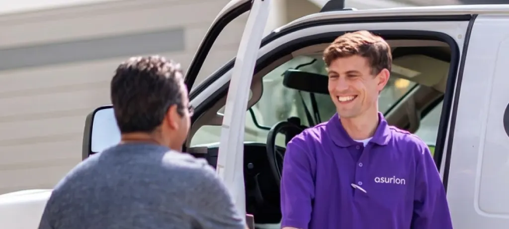 Asurion employee in a purple shirt shaking hands with a customer