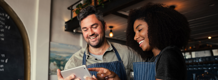 Man and woman behind counter using tablet