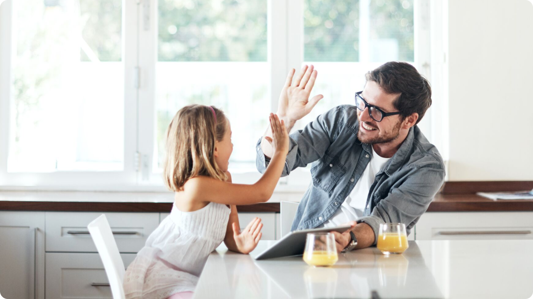 Little girl high fives her dad in the kitchen