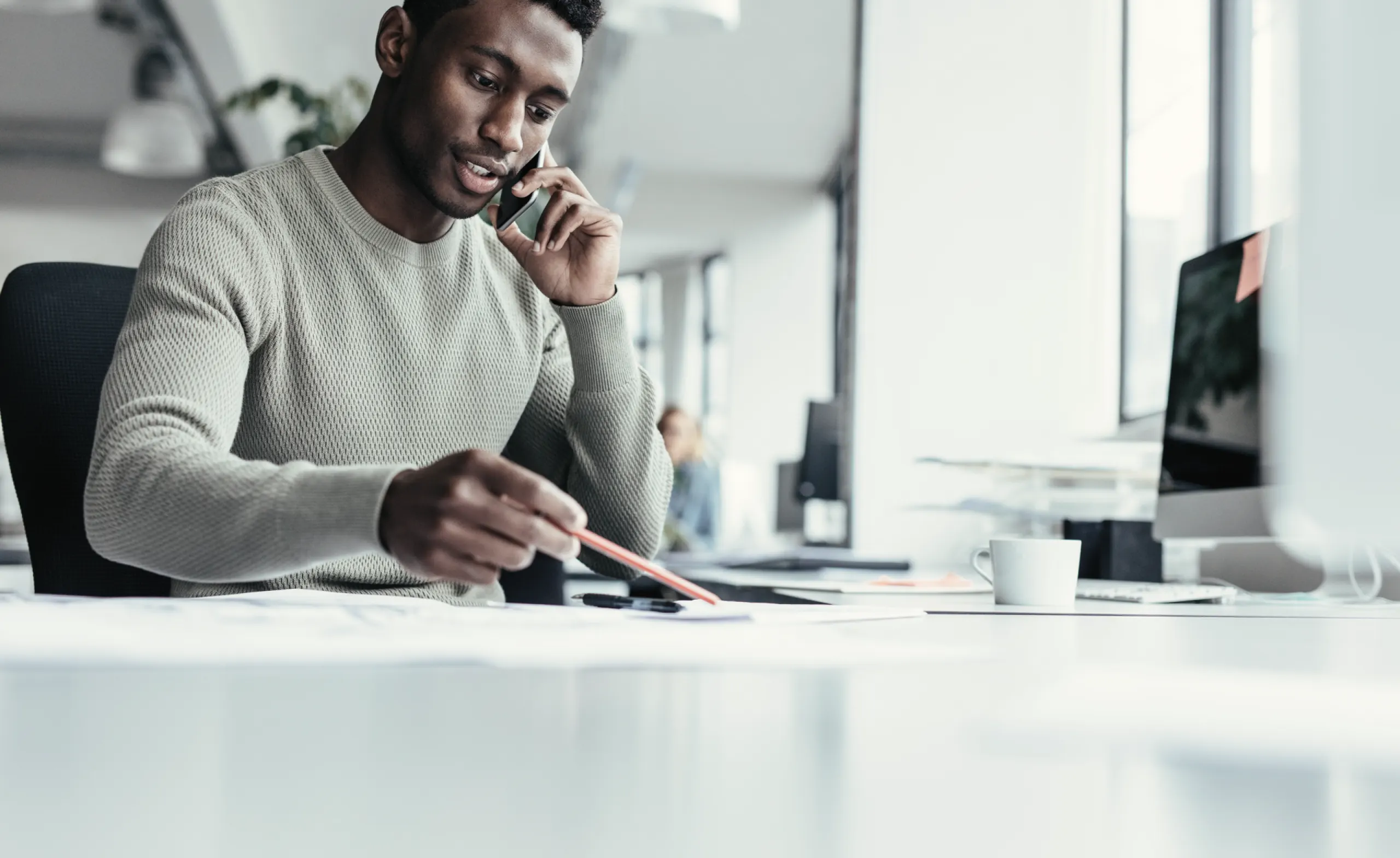 Man working at desk with phone and computer