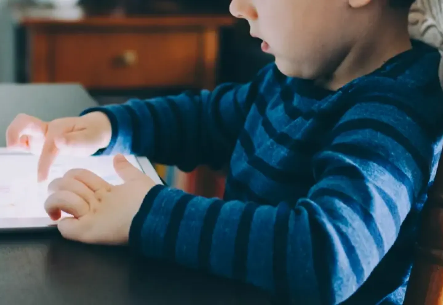 A young child playing with a laptop