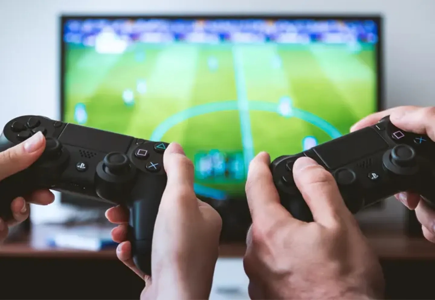 Two people holding multiplayer controls in front of a television