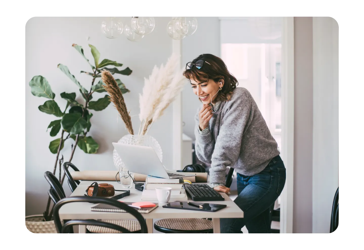 Woman with headphones working on laptop at table