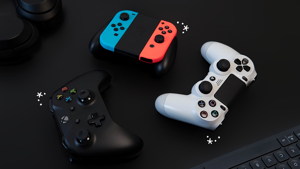 Xbox, PlayStation and Nintendo Switch controllers arranged on a table
