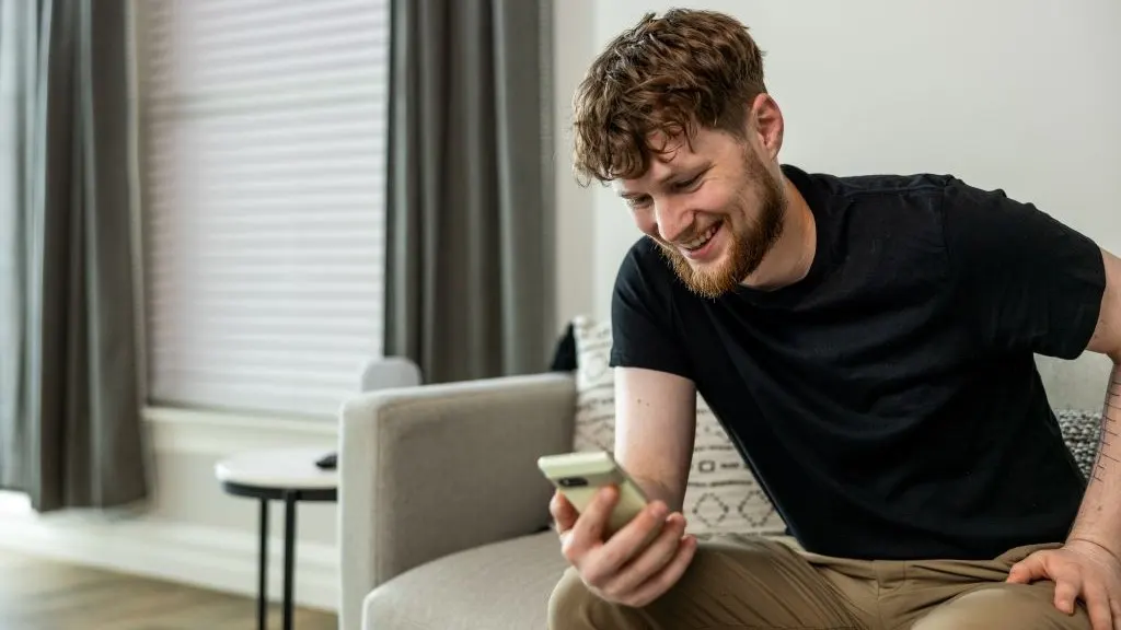 Man looking at phone and smiling
