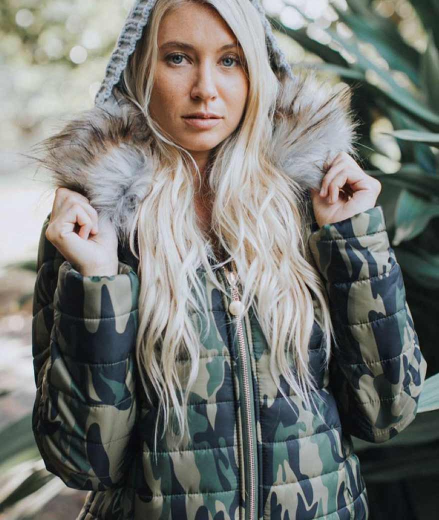 A woman models a dark green camouflage parka.