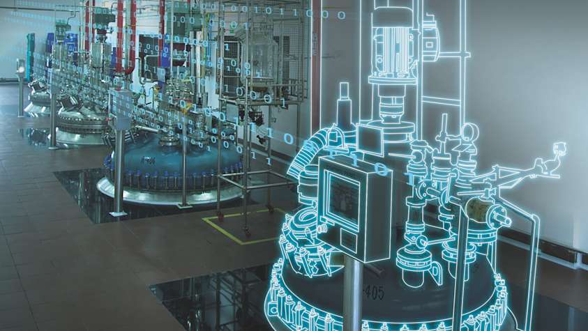 Person in black shirt standing against white wall, holding a dark object with blurred background.