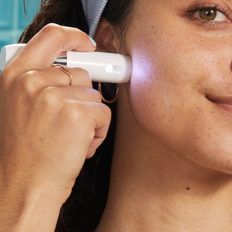 Young lady using Facial Hair & Skin Trimmer on the go