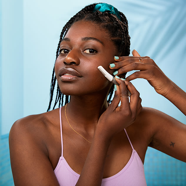 A woman using a Gillette Venus facial razor on her left cheek