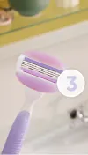 Purple colored refillable Gillette Venus razor with a focus on its razor head and 3 blades