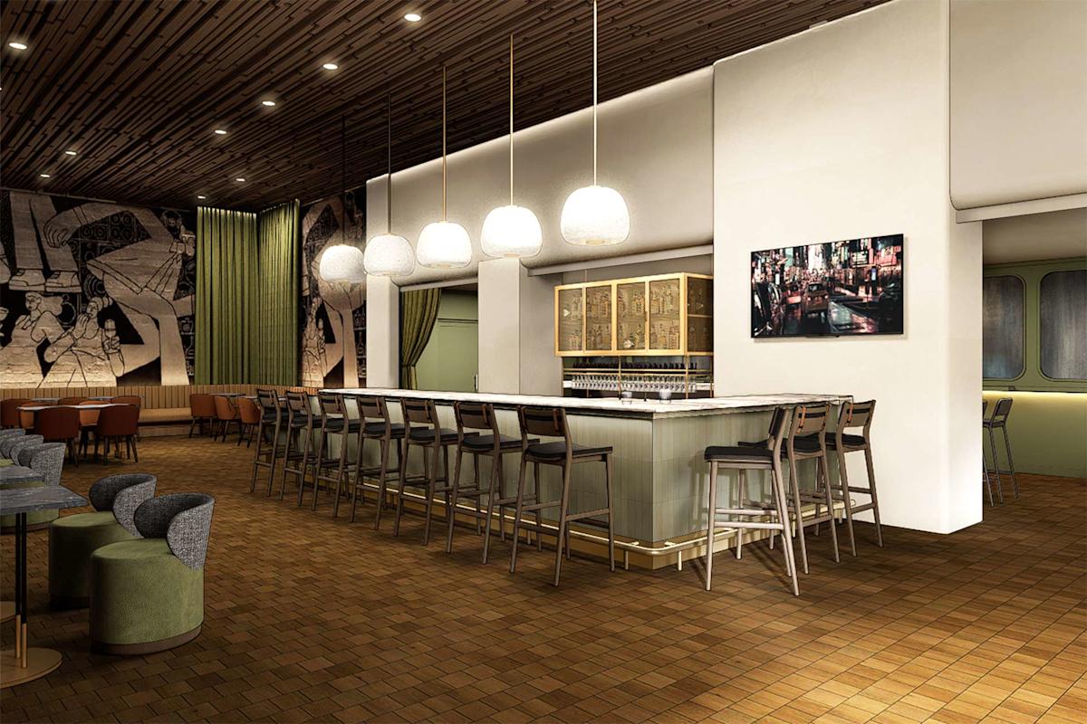 Modern bar interior with a long counter lined with tall chairs, pendant lights above, wooden ceiling, mural on the far wall, and a framed photograph on a white wall. Warm, inviting atmosphere with stylish furnishings.