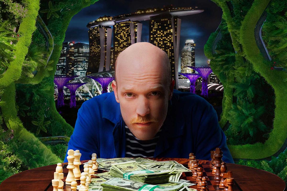 A person with a serious expression sits at a table covered with chess pieces and stacks of dollar bills. The background features the illuminated skyline of a city with futuristic buildings and lush greenery.