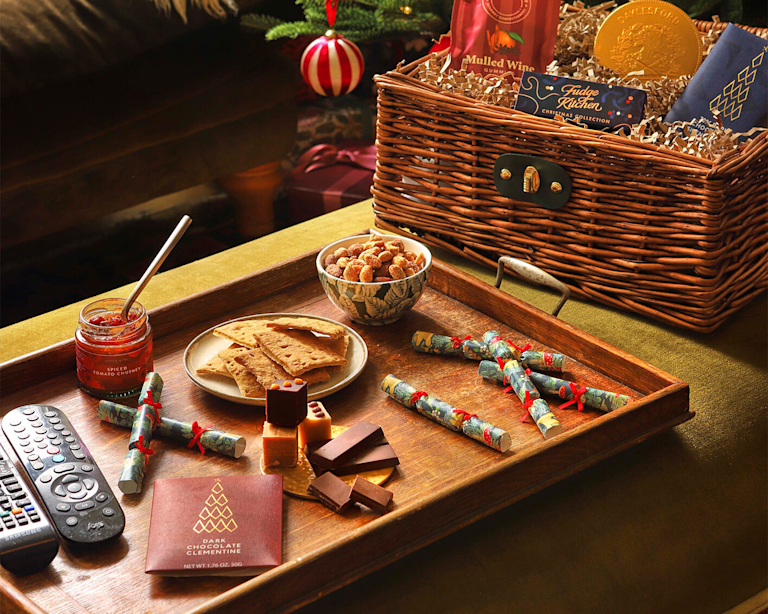 A Bloom & Wild Hamper featuring christmas crackers, chocolate , nuts and crackers