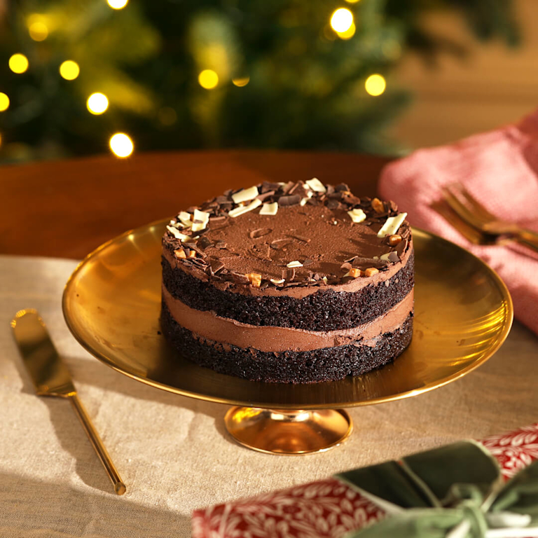 Bloom & Wild chocolate fudge cake on a gold stand
