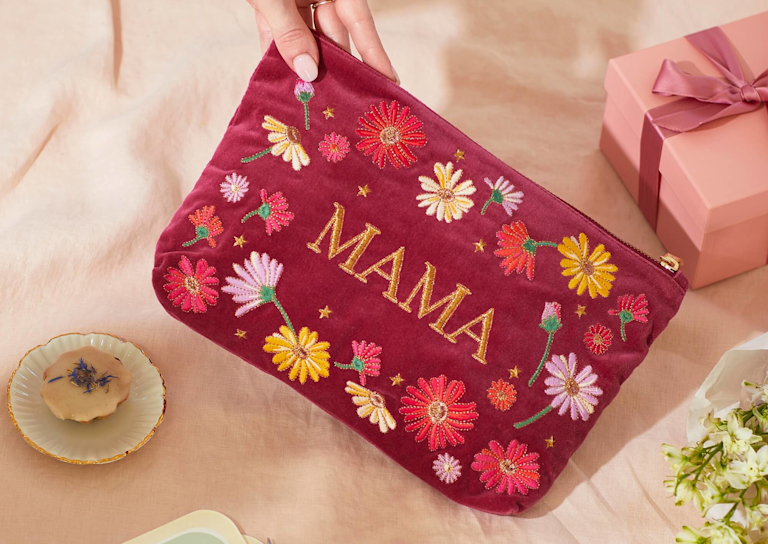 An assortment of vibrant bouquets, greetings cards and sweet treats are dotted around an open space, against a deep green background. The Bloom & Wild and Liberty logos appear over the top.