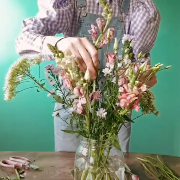 Harriet places a snapdragon in the centre of the arrangement