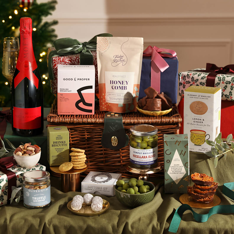 A large wicker hamper featuring champagne, biscuits, nuts, truffles and tea