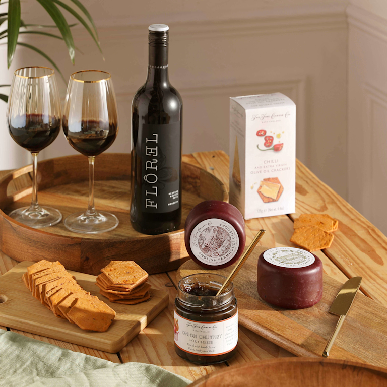 A Bloom & Wild Hamper featuring wine, cheese, crackers and chutney