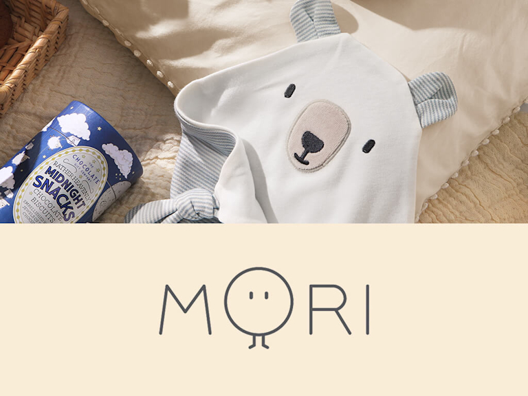 A white, grey and blue striped baby comforter in the shape of a bear's face.